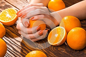 Orange manicure with oranges. on the wood
