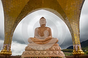 Orange marble buddha statue in meditation pose