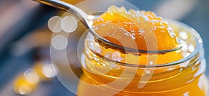 Orange marmalade. Spoon scooping homemade orange jam from a glass jar surrounded by fresh oranges