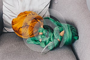 Orange merino wool ball with green knitted blanket