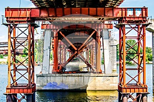 Orange metal supports of the fishing bridge over the river Dnieper.