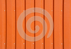 Orange metal tile fence background. Fence from corrugated board. Terracotta slate background. Zinc metal sheet texture. Steel