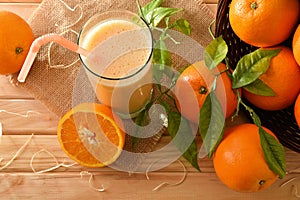 Orange milkshake and pieces of fruit on wooden table top view