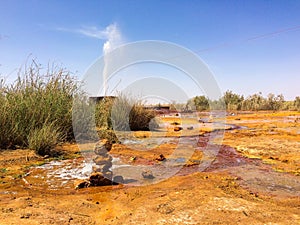 Orange mineral pool of natural water spring in Damia with stream or rising spring to the air