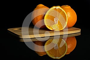 Orange minneola tangelo isolated on black glass