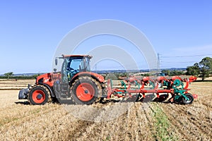 Kubota M7-173 ploughing on stubble in crop field