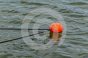 An orange mooring buoy on the lake