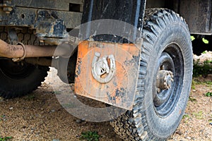 Orange mudflap with decoration attached to truck arch.