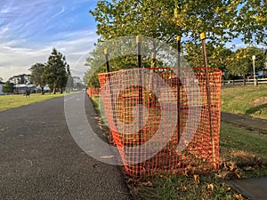 Orange netting along park pathway