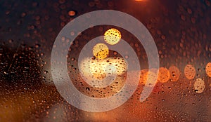 Orange night light bokeh from street light on traffic jam day. Rainy day. Transparent glass window with rain drop. Romantic weathe