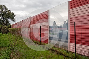 Orange noise protection wall on a freeway. Highway noise barrier