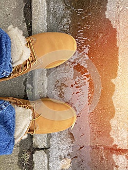 Orange nubuck boots and blue jeans on mens legs. Autumn fashion concept. Top view. Vertical shot