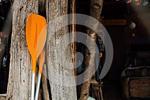 Orange oars on a wooden background. Two orange paddles for a sea boat or kayak