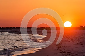 Orange Ocean beach sunset.  Tropical Gulf Coast ocean beach sunset scene.