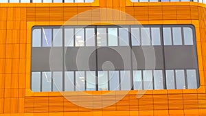 Orange office building facade with rectangular window. Abstract background. Convention center. Urban real estate. Modern architect