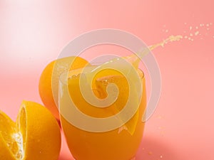Orange and orange slice. Orange Juice Splashing. Orange on a pink background.