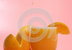 Orange and orange slice. Orange Juice Splashing. Orange on a pink background.