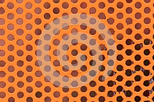 Orange painted circle perforated metal panel texture and background