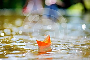 Orange paper boat with a white flag