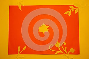 orange paper with yellow flowers and jungle leaves along the edge of the frame, around orange paper yellow background
