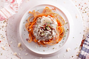 Orange pasta and white sauce served on white plate