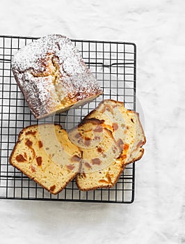 Orange peel dried apricots greek yogurt cake on a baking rack on a light background, top view