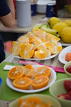 Orange peeled slices in bowls, party table