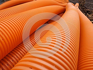 Orange perforated drainage pipe, corrugated.