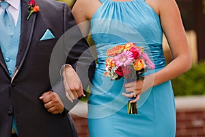 Bridesmaid and groomsman walking down the aisle with colorful bo photo