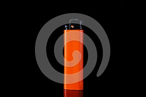 Orange plastic cigarette lighter on black background, closeup