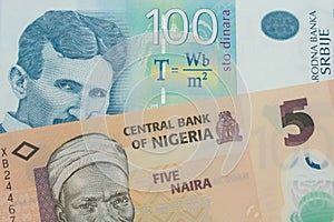 A orange, plastic five naira note from Nigeria paired with a bue and white one hundred Serbian dinar note.