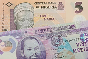 A orange, plastic five naira note from Nigeria paired with a purple, plastic twenty metical note from Mozambique.