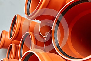 Orange plastic pipes lie in rows