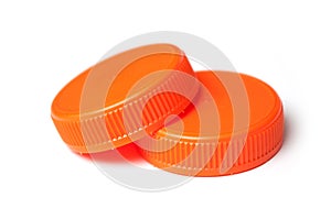 Orange plastic plugs for recycling on white background