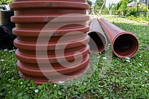 Orange plastic sewer pipes. Home yard. Reconstruction and construction site