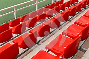 Orange plastic spectator seats in diagonal view, sport venue equipment