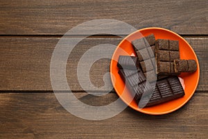 Orange plate with delicious and healthy hematogen on wooden table, top view. Space for text