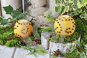 Orange pomander ball with candle on wooden table