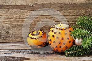 Orange pomander ball with candle on wooden table