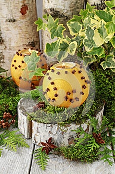 Orange pomander ball with candle on wooden table