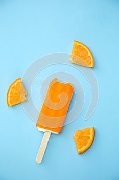 Popsicle with fresh orange on a table