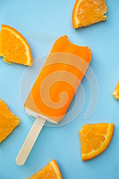 Popsicle with fresh orange on a table