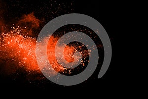 Orange powder explosion on black background.
