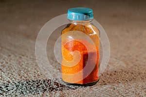 Orange poweder Ammonium dichromate in a glass bottle