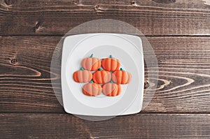 Orange pumpkin candies on wooden table