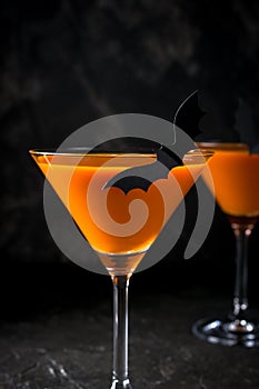 Orange pumpkin martini Halloween drink for party over black background. copy space