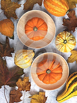 Orange pumpkin surrounded by autumn leaves