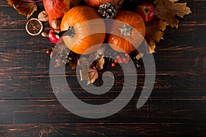 Orange pumpkins, fallen leaves, apples, nuts, berries on wooden background. Concept autumn template, blank halloween or