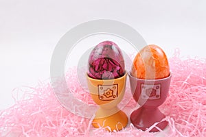 Orange and purple Easter eggs in eggcups