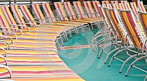 Orange and Red Chaise Lounges on Green Deck